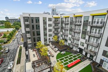 An aerial view of an apartment complex with a green courtyard